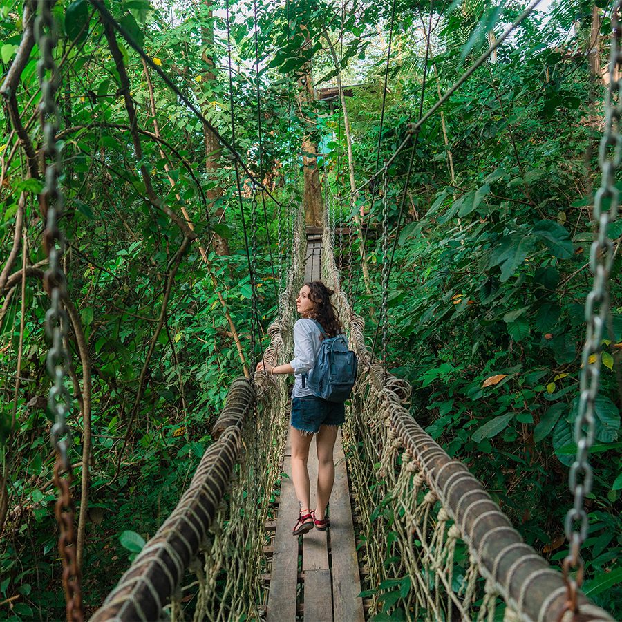 Woman walking on rope bridge